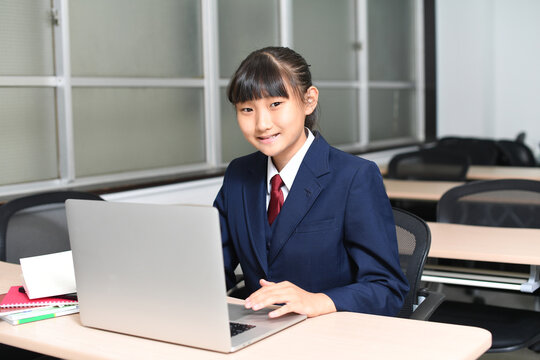 パソコン操作をする制服を着た女子学生
