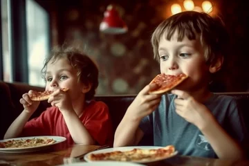 Tuinposter Children eat pizza in a cafe. children eat unhealthy food. © Рика Тс