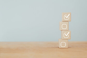 Check mark icons for jobs list on the face of wooden stacked blocks. Task lists, Checklist, Survey,...