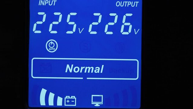 Close up of blue digital display on uninterruptible power supply with automatic voltage stabilizer