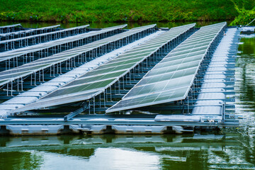 Side view of solar panels floating on water in a lake, for generating electricity from sunlight, selective focus, soft focus.