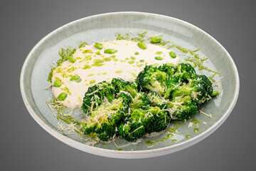 Steamed brocolli with cream sauce and parmesan. Isolated on a white background.