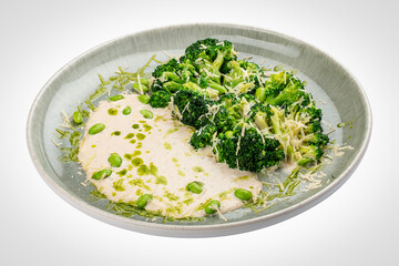 Steamed brocolli with cream sauce and parmesan. Isolated on a white background.