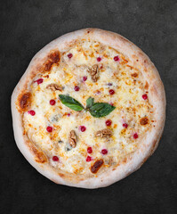 Pizza Four Cheese with smoked suluguni, gorgonzola, mozzarella, mountain ash, walnuts, honey, basil. Neapolitan round pizza on dark background