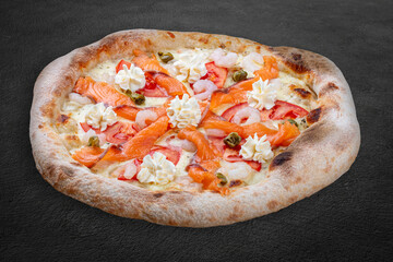 Philadelphia pizza with salmon, shrimps, tomatoes, mozzarella, capers, Philadelphia cheese. Neapolitan round pizza on wood background