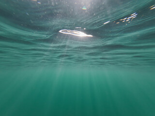 Underwater photo.  The rays of the sun break through the water.  Photo texture.