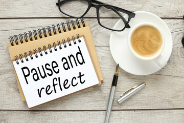 pause and reflect wooden background. business and finance concept. On the table are a pen and a...