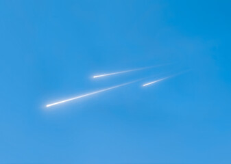 Meteors light up the blue sky. Shooting stars in the light of the sun. Fireballs in the daytime.