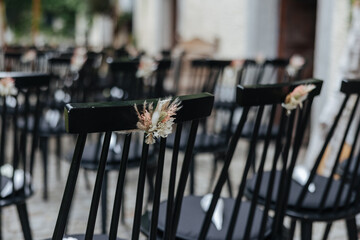 Fototapeta na wymiar Decoration on the chairs at a wedding venue before the ceremony