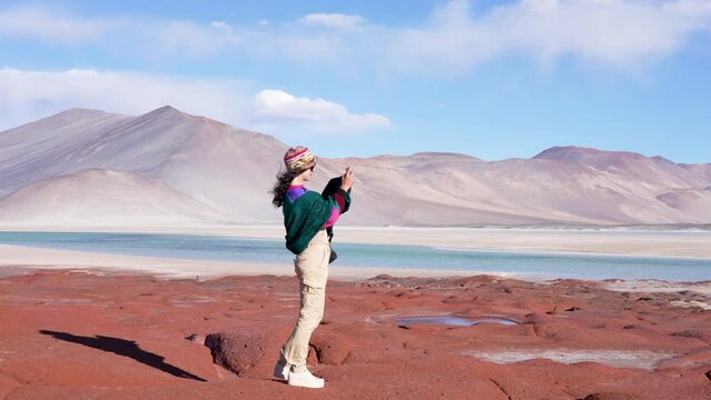 tourist woman recording the beautiful landscape with her cell phone in Las Piedras Rojas in Salar de Aguas Calientes of San Pedro de Atacama	