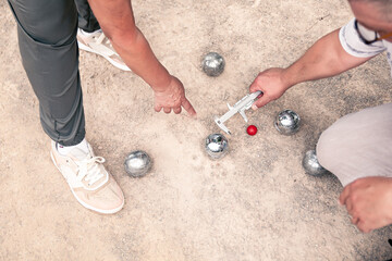measuring the distance of the pétanque balls to see the winner