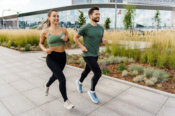 Athletes exercise for health. Happy people jogging together. Runners partners training in sports clothes and running shoes.  Use a fitness watch and a cardio app.