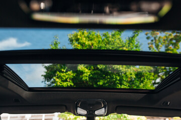 Panoramic sunroof at the car and blue sky. Clean sunroof and view of the sky from the inside or car interior