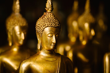 Closeup head shot of Buddha statue on yellow light background