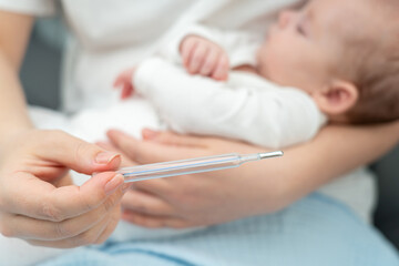 Mother checks newborn's temperature, Concept of healthcare at home