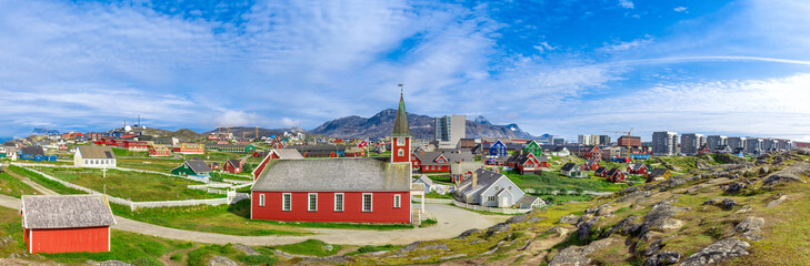 Typical architecture of Greenland capital Nuuk with colored houses located near fjords and icebergs.