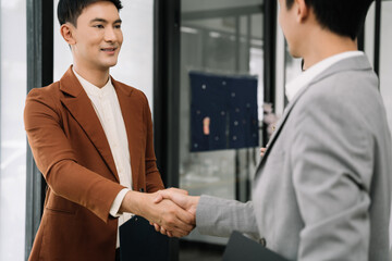 Businessmen shake hands after agreeing to start a new project successfully.