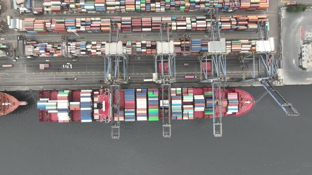 Aerial Birds Eye View Over Container Ship Docked At Karachi Port Trust Terminal. Pedestal Up