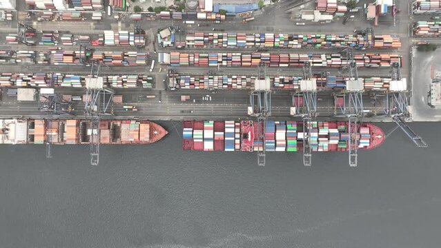 Aerial Birds Eye View Over Container Ships Docked At Karachi Port Trust Terminal. Truck Left