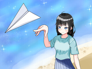 海辺で紙飛行機を飛ばす女性