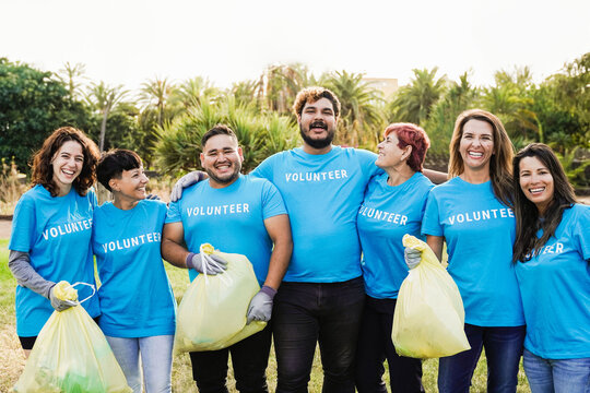 Happy volunteers helping community clean and recycle plastic at nature park city - People from different ages and ethnicity work together for environment support