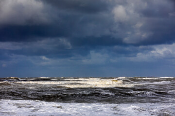 stormy weather with dark clouds and rough waves on the North Sea along the Dutch coast
