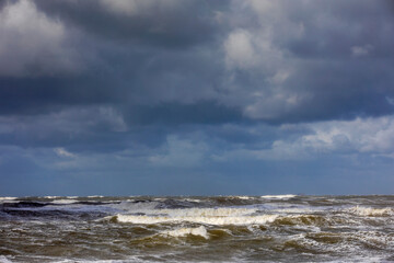 stormy weather with dark clouds and rough waves on the North Sea along the Dutch coast