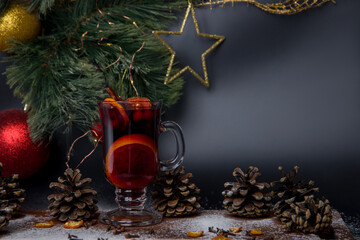 Mulled wine with spices and christmas decoration on dark background