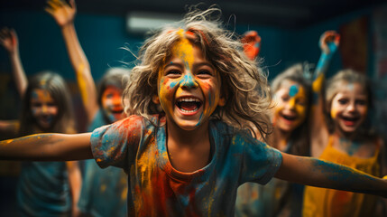 Excited kids covered in paint, arms raised, smiling at the camera