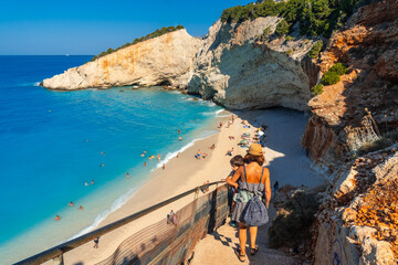 Woman walking down the stairs leading to Porto Katsiki beach on Lefkada island in summer, Greece