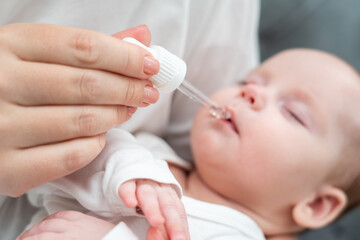 Mother administers oral drops to newborn, Concept of ensuring baby's health