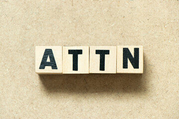 Alphabet letter block in word ATTN (Abbreviation of attention) on wood background