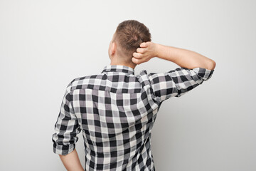 Portrait of clever man in shirt touching head thinks doubts chooses isolated on white studio background with copy space, back view