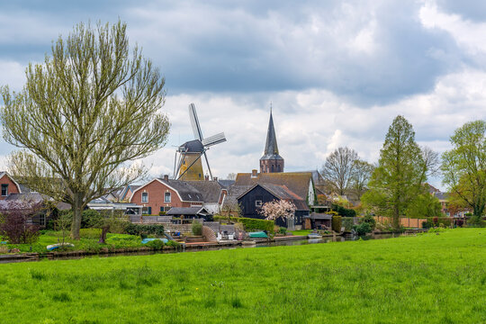 A typical Dutch image of a windmill and a church in the town of Cothen in the Betuwe, the Netherlands