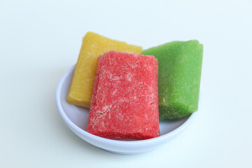 Yangko is traditional snack from Yogyakarta, Indonesia. Made from glutinous rice powder. Colorful yangko on plate plate, isolated on white background