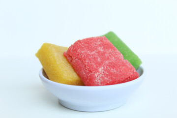 Yangko is traditional snack from Yogyakarta, Indonesia. Made from glutinous rice powder. Colorful yangko on plate plate, isolated on white background