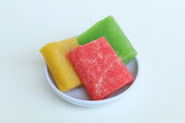 Yangko is traditional snack from Yogyakarta, Indonesia. Made from glutinous rice powder. Colorful yangko on plate plate, isolated on white background