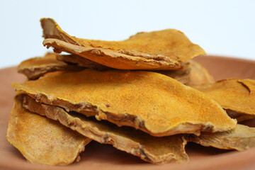 Sliced and dried rhizome of Curcuma zanthorrhiza, or temulawak, or Java ginger, or Javanese ginger, or Javanese turmeric. Isolated on white background