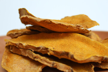 Sliced and dried rhizome of Curcuma zanthorrhiza, or temulawak, or Java ginger, or Javanese ginger, or Javanese turmeric. Isolated on white background