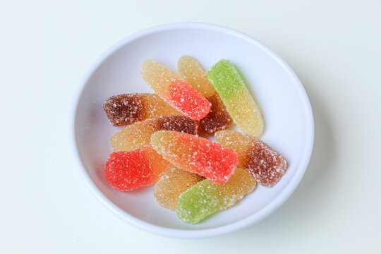 Colorful gummy candies with sugar coat. In a white bowl. Isolated on white background