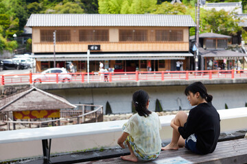 夏の修善寺の温泉街の足湯を楽しむ子供姉妹の姿
