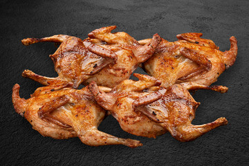 Grilled quail, handmade on a dark stone backdrop. BBQ menu