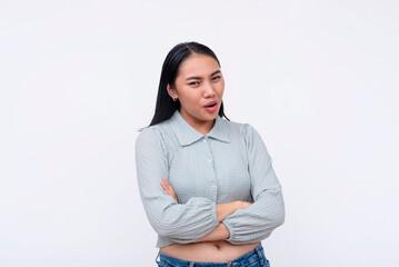 A skeptical young asian woman with crossed arms scoffs at some dubious claims. Isolated on a white background. - obrazy, fototapety, plakaty