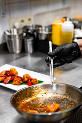 chef cooking chicken sweet and sour sauce on kitchen