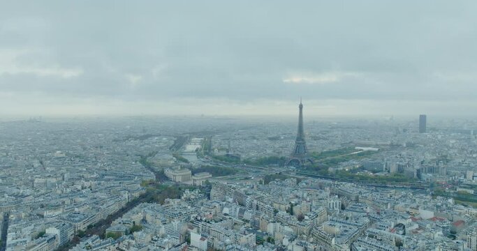 Beautiful view of famous Eiffel Tower in France with magical morning cloud and fog. Wide establishing aerial drone fly over seine river in paris city center, best travel destination landmark in Europe