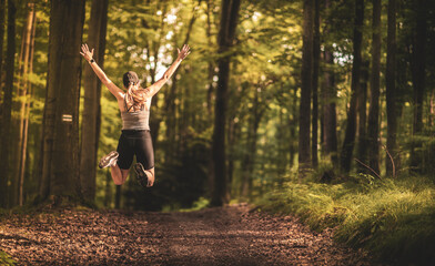 Fitness happiness. Happy woman jumping in the forest. Running in the forest. - 640675848