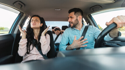 Family having quarrel in car, husband shouting at wife while driving auto, child sitting on back...