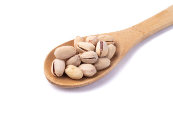 Salted roasted pistachios on a spoon isolated over white background