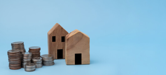 Stacked of Coins and House Model. Business investment and saving money finance, tax Interest rates for loans and real estate prices concept.
