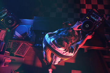 Anonymous DJ performing music in dark club